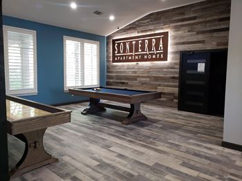 a game room with a pool table and a soterra rental house sign